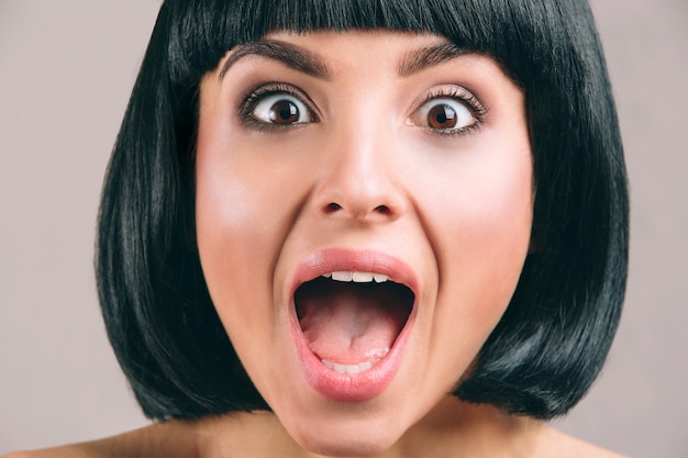 Photo young woman with black hair posing. emotional young brunette screaming. bob haircut. short black hair. young woman