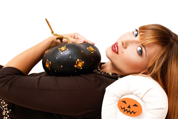 Foto giovane donna con zucca nera nella decorazione di halloween