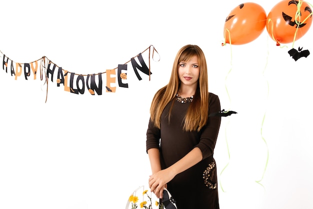 Giovane donna con zucca nera nella decorazione di halloween