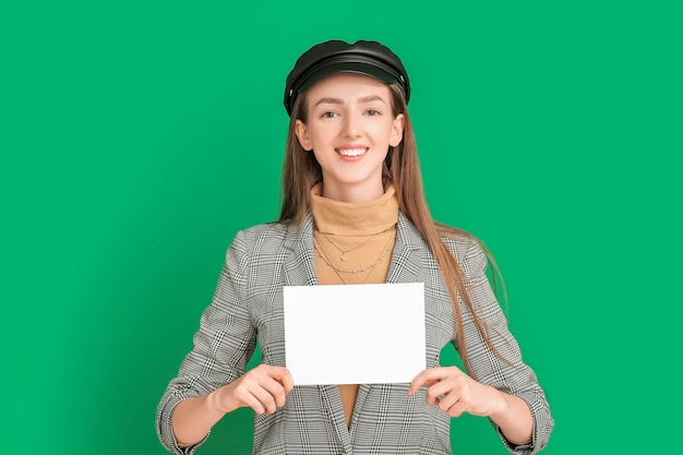 Young woman with blank card on color background