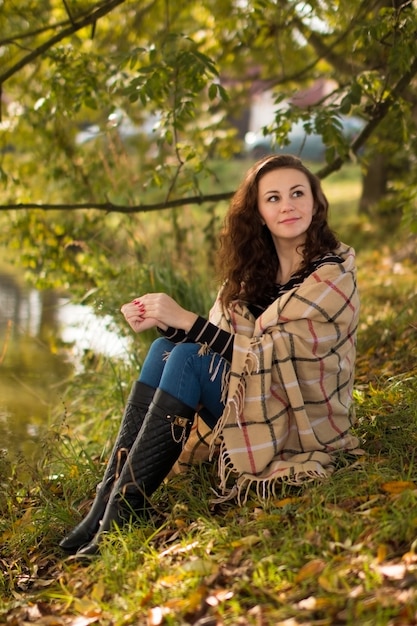 Young woman with blanket in the park in the autumn