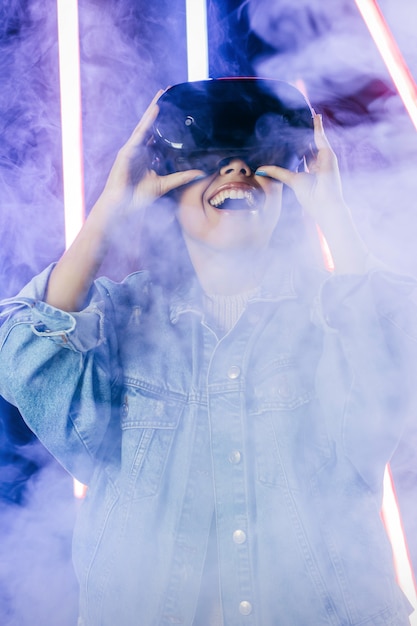 Young woman with blue denim jacket using virtual reality glasses