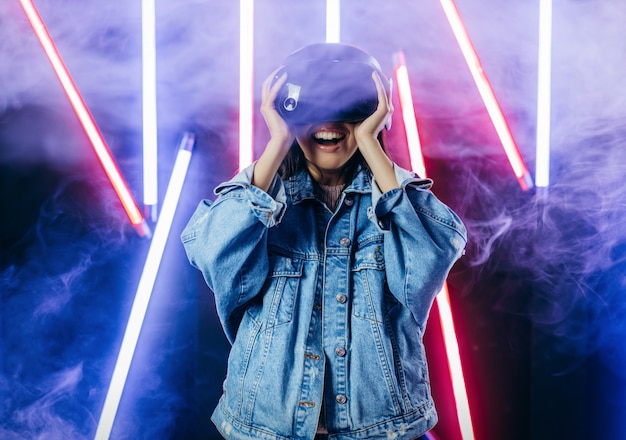 Young woman with blue denim jacket using virtual reality glasses