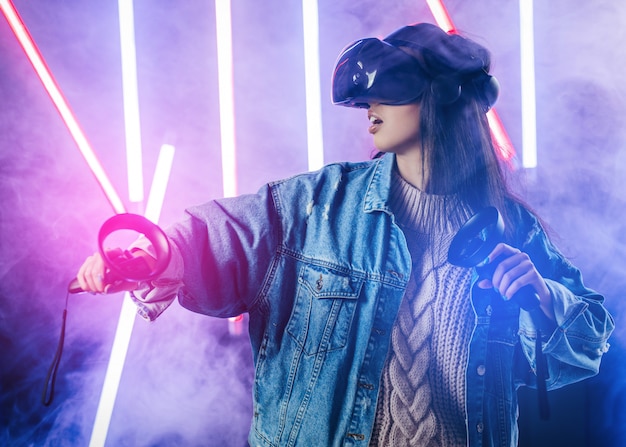 Молодая женщина с синей джинсовой куртке, используя очки виртуальной реальности