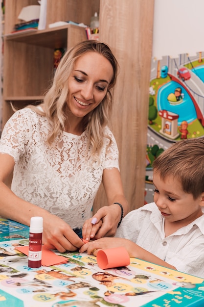 Young woman with boy glue the craft