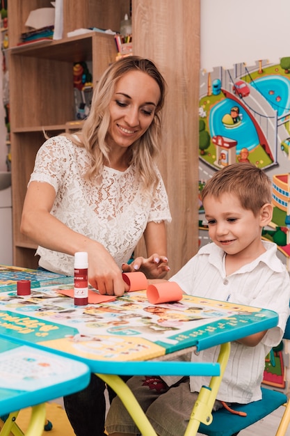 Young woman with boy glue the craft