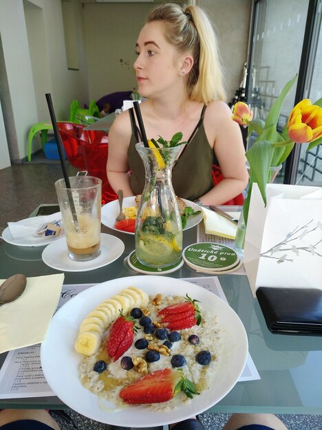 Young woman with breakfast on table