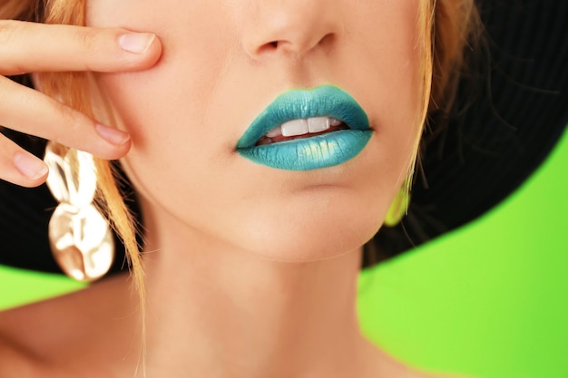 Young woman with bright green makeup on color background closeup