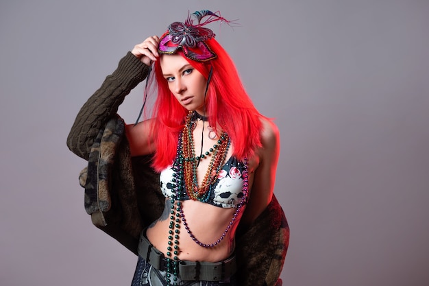 Young woman with bright pink hair in a mardi gras costume