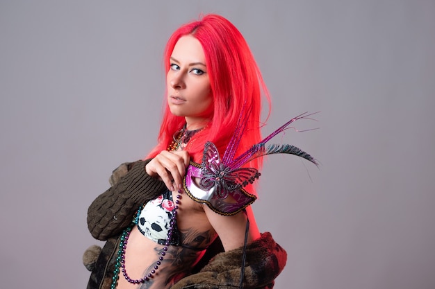 Young woman with bright pink hair in a mardi gras costume