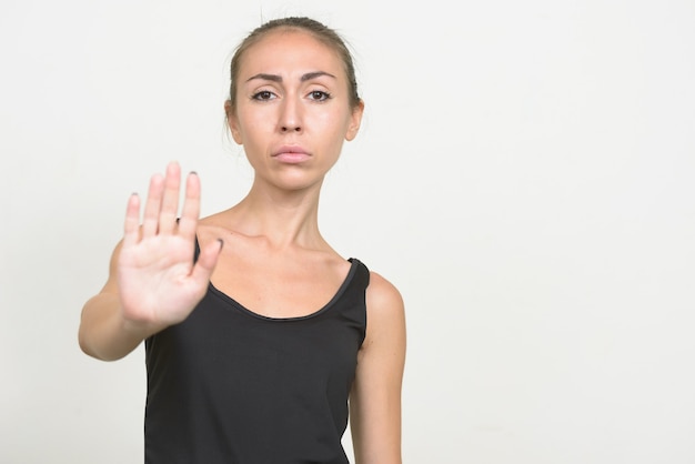 Young woman with brown hair showing stop gesture