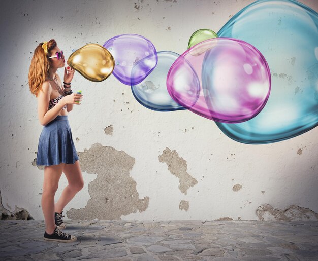 Foto giovane donna con bolle sullo specchio contro il muro