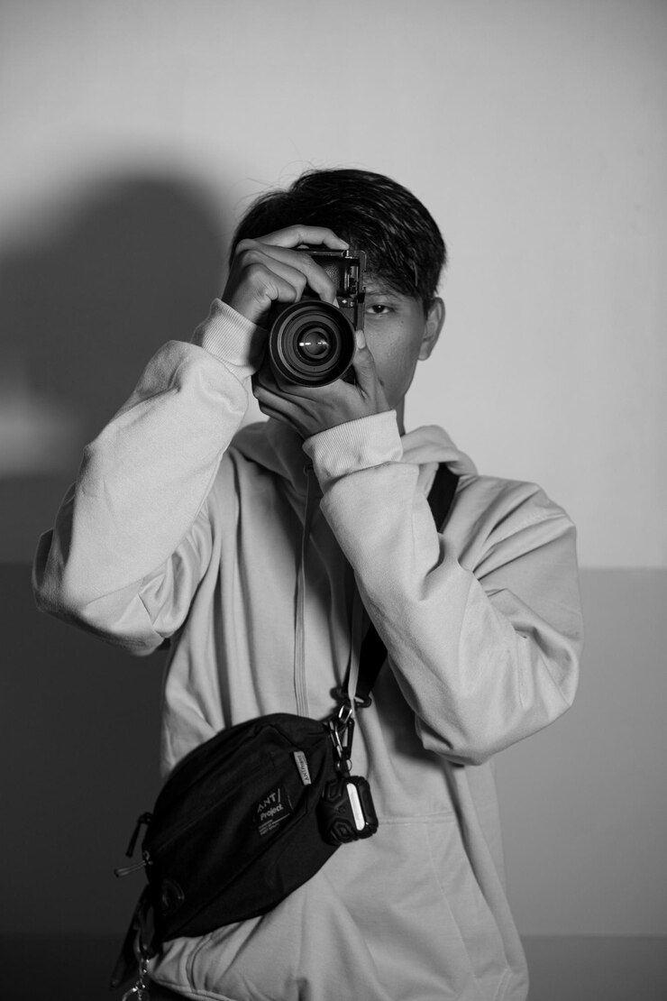 Photo 벽에 카메라를 든 젊은 여성