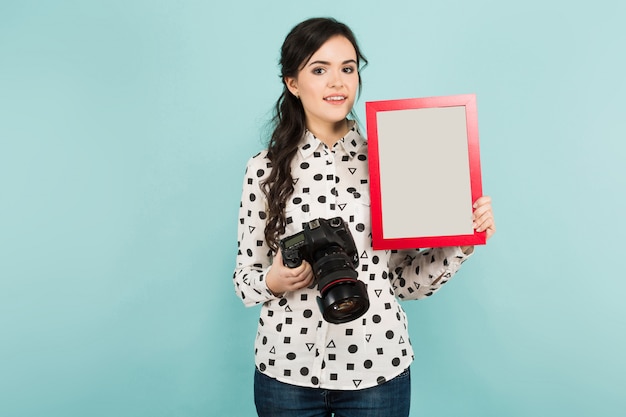 Young woman with camera and frame