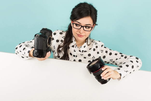 Young woman with camera and lens