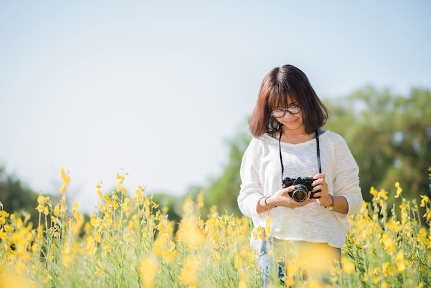 Sunhemp 정원에서 카메라와 함께 젊은 여성