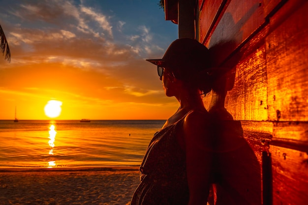 A young woman with a cap at Sunset on West End Beach Roatan Island Honduras