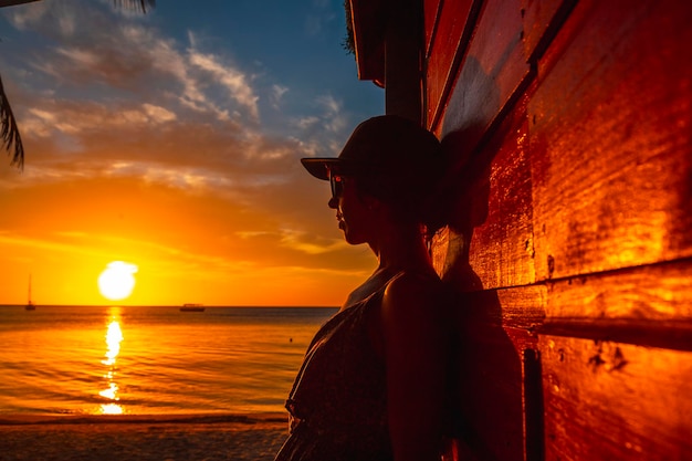 A young woman with a cap at West End Sunset in the Caribbean Sea Roatan Island Honduras