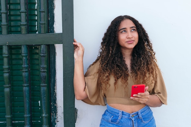 写真 屋外で携帯電話を持つ若い女性