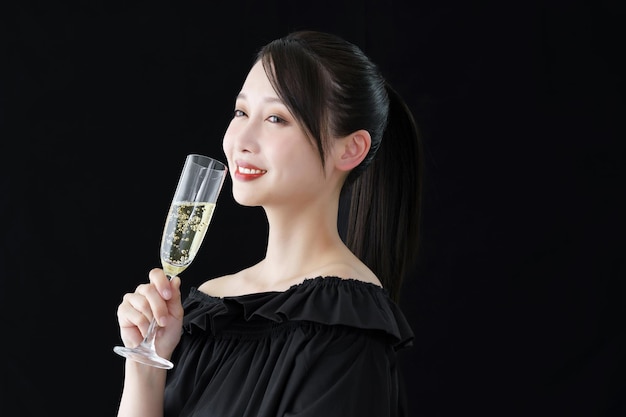 Young woman with champagne glass and black background