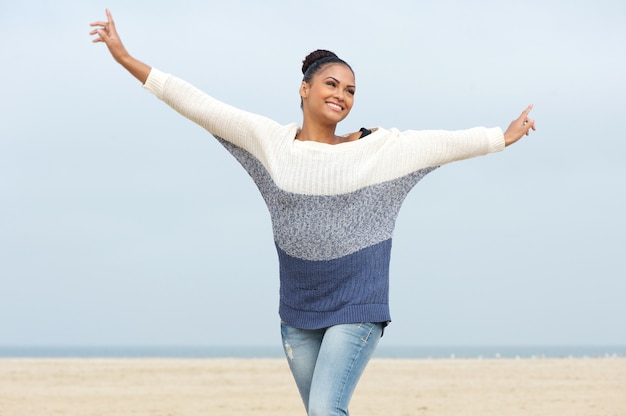 Young woman with cheerful expression and arms outstretched