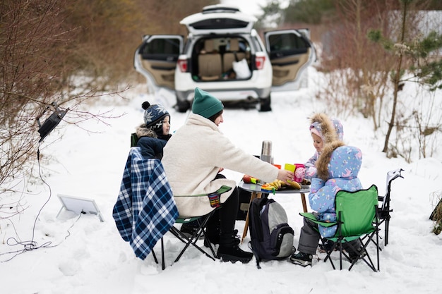 写真 ピクニックに冬の森で子供を持つ若い女性母と 3 人の子供