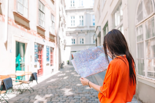 Foto giovane donna con una mappa della città in città.