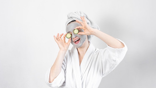 A young woman with a clay mask on her face