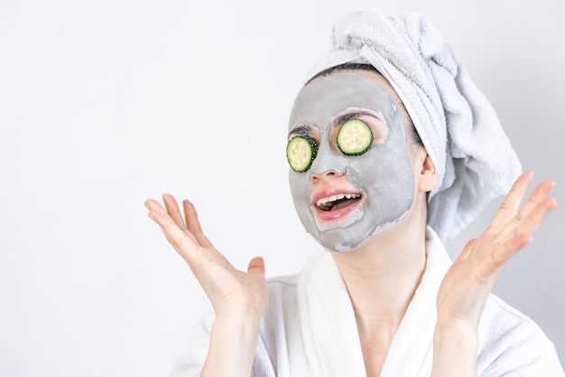 Photo a young woman with a clay mask on her face