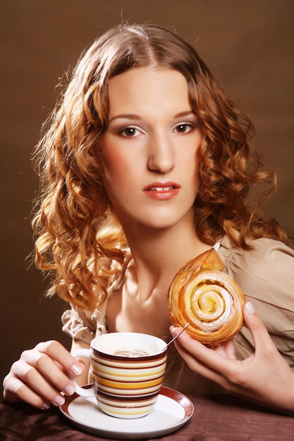 Foto giovane donna con caffè e torta