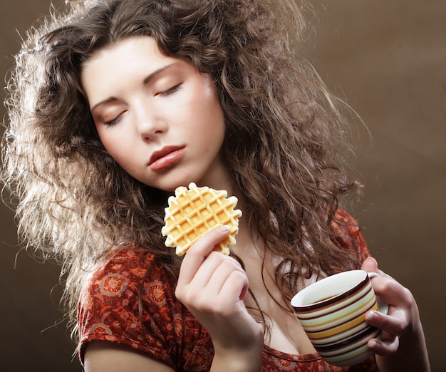 Young woman with coffee and cookies