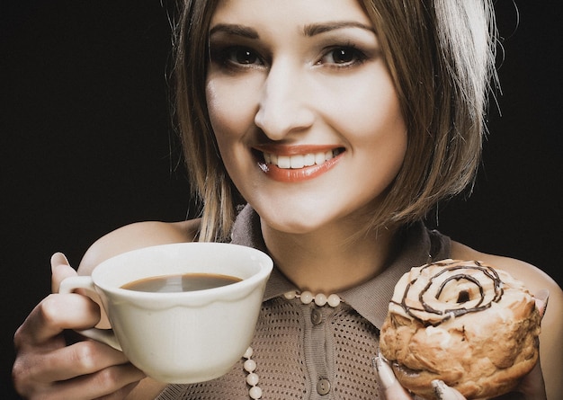 コーヒーとクッキーを持つ若い女性
