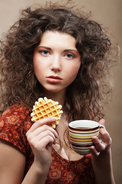 Young woman with coffee and cookies