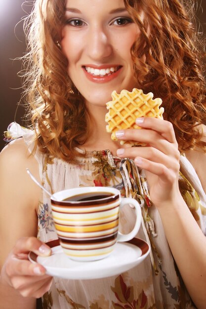 Молодая женщина с кофе и печеньем