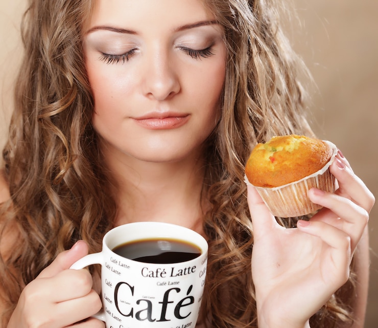 Photo young woman with coffee and muffin