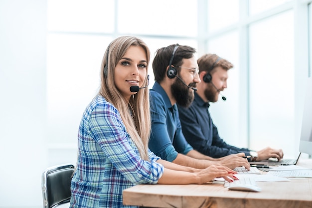 Young woman with colleagues working in the office of the call center