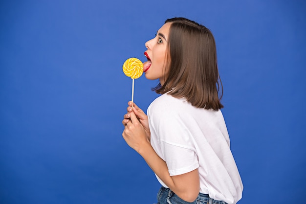 Photo young woman with the colorful lollipop at studio