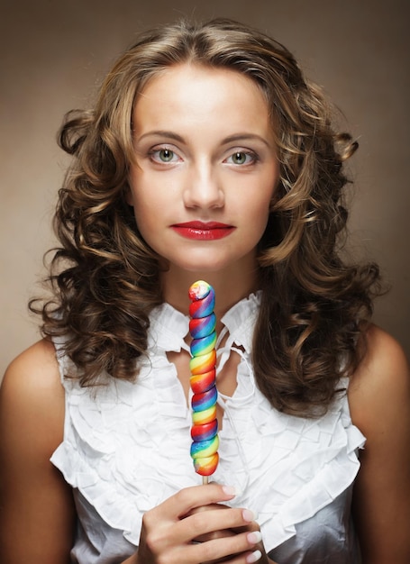 Giovane donna con lecca-lecca colorata