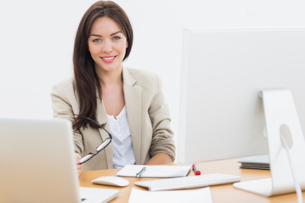 Young woman with computers at desk in office