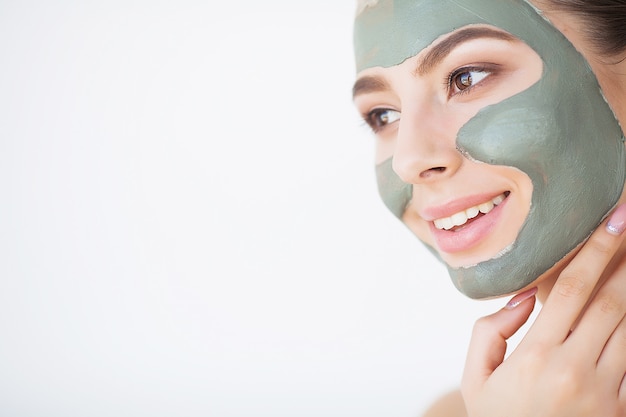 Photo young woman with cosmetic clay mask