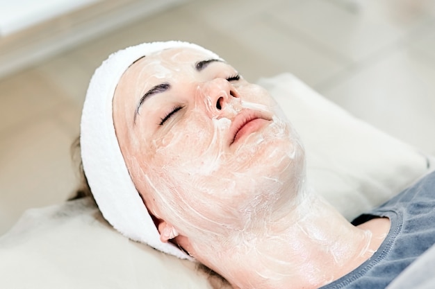 Young woman with a cream applied on face