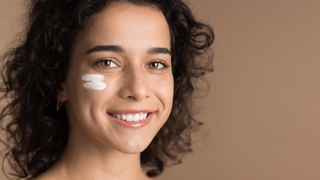 Young woman with cream under her eye