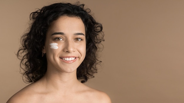 Photo young woman with cream under her eye