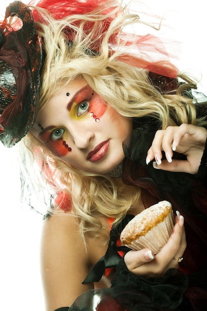 Young woman with creative makeup with cake