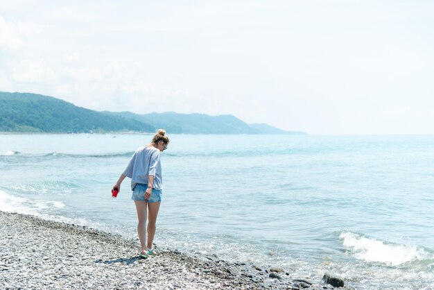 A young woman with a cup of coffee on the beach Summer Vacation