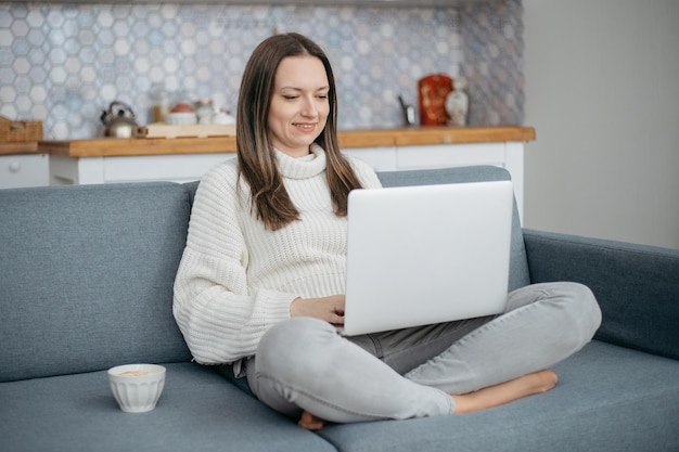 ソファに座っているコーヒーの若い女性