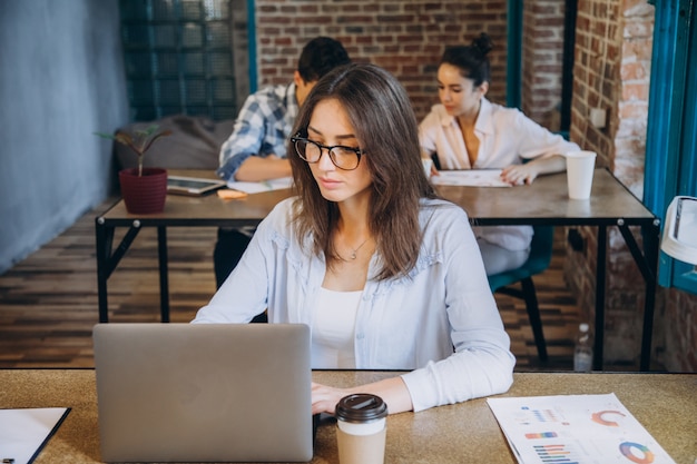 Young woman with cup of coffee working