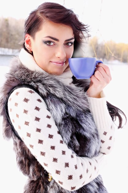 Foto giovane donna con una tazza di bevanda calda