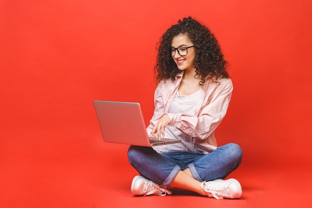 Young woman with curly brunet hair with laptop