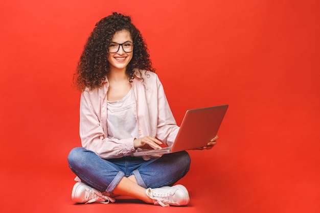 Young woman with curly brunet hair with laptop